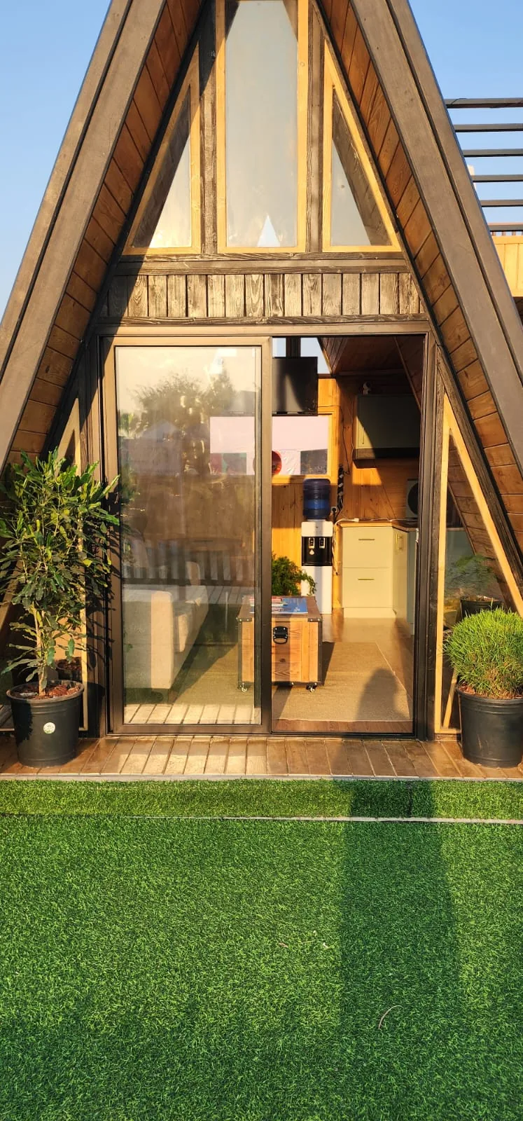 Grande baie vitrée coulissante du pignon A-Frame, intérieur lambrissé visible