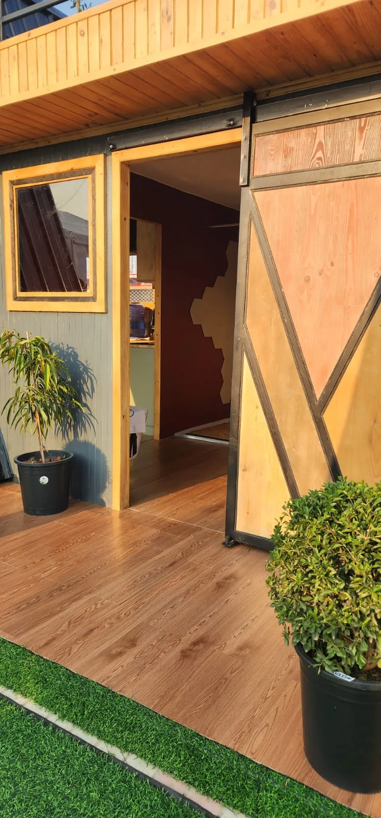 Porte coulissante style grange en bois et cadre acier, entrée du module