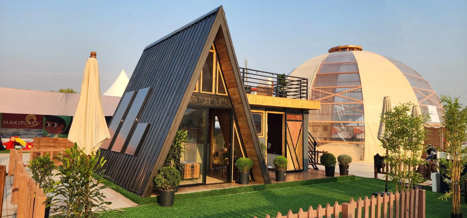 Maison A-Frame HazoVy&Co. au toit noir, module attenant avec terrasse sur le toit, en exposition à Antananarivo
